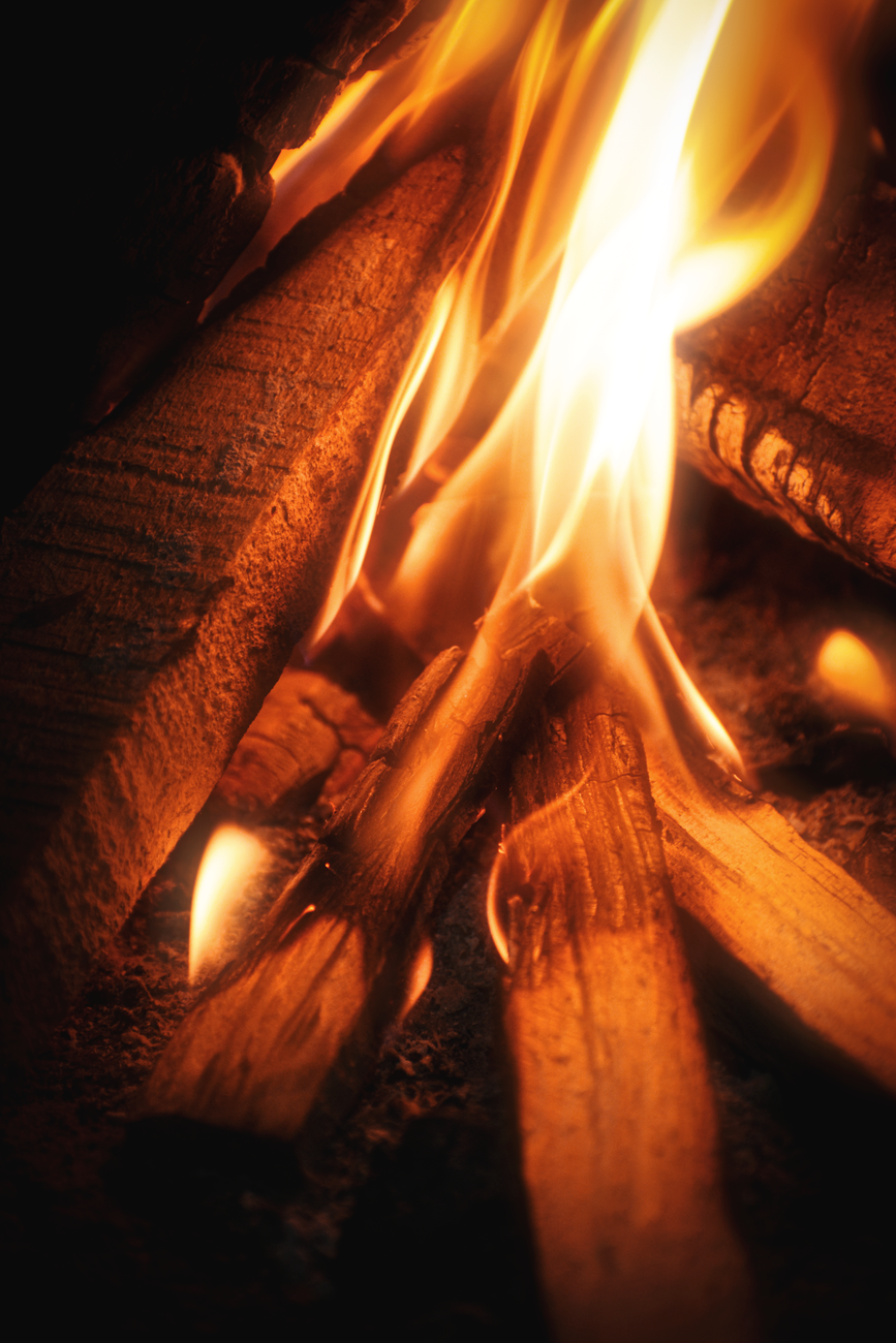 Close-up of vibrant bonfire flames, capturing the warmth and glow of a night fire.