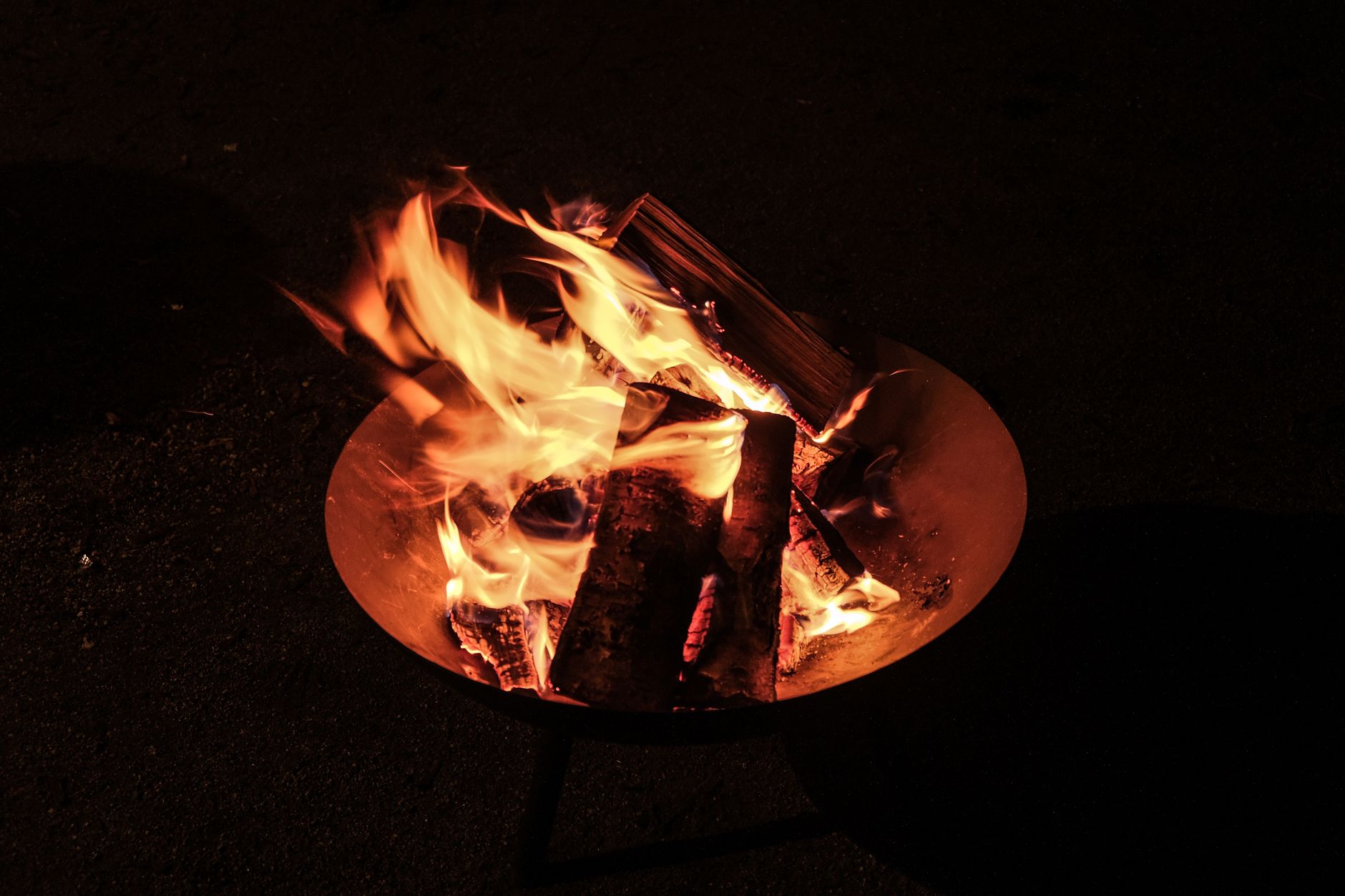 A close-up view of a campfire, showcasing vibrant flames against a dark night backdrop.